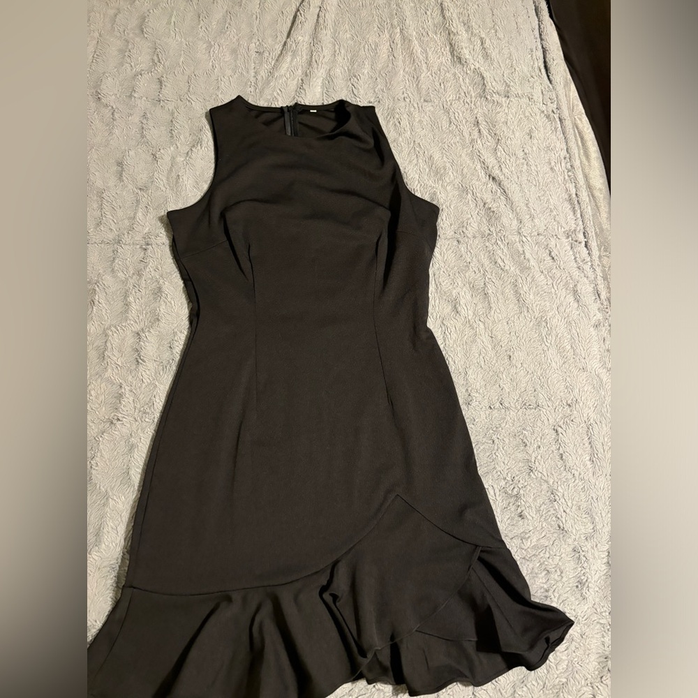 Women’s sleeveless black mini dress ruffle hem.